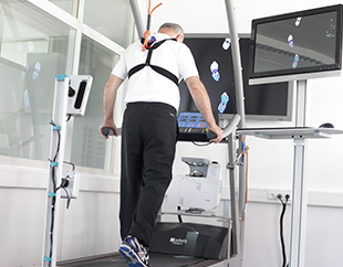 A man walking on a treadmill in an office.